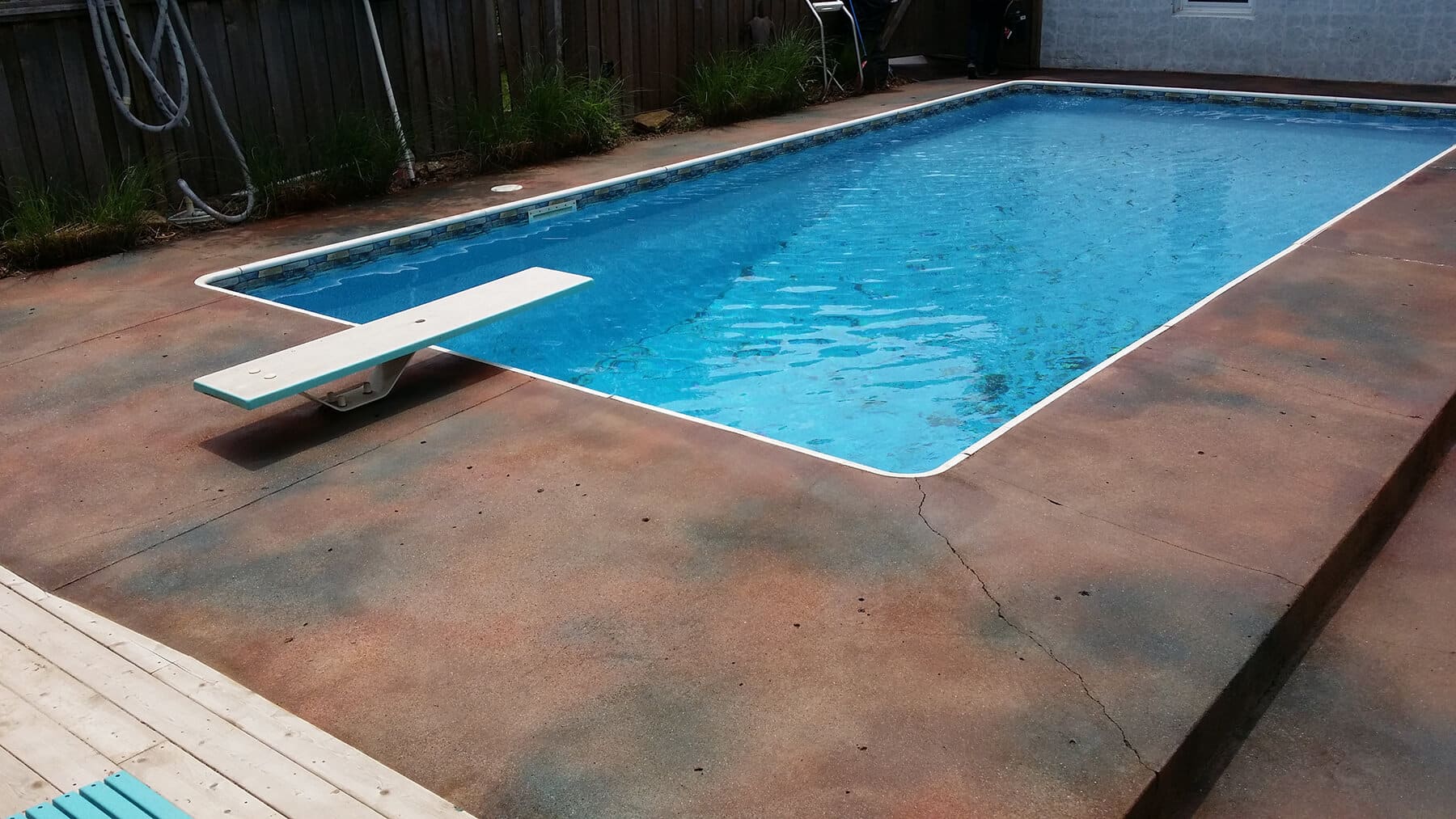 Pool deck of concrete in Kansas City, with diving board