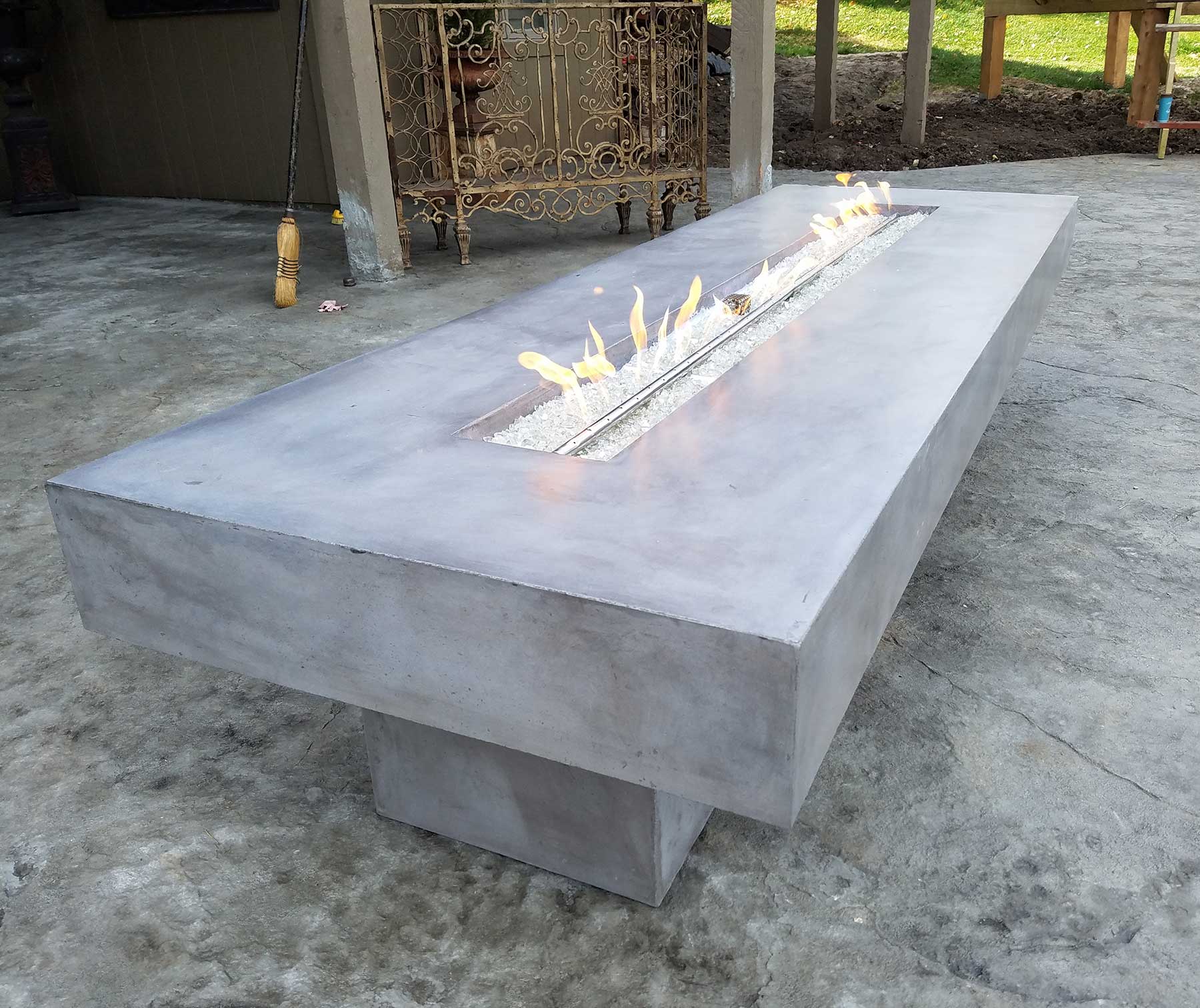 gray concrete gas-powered firepit, with white rock